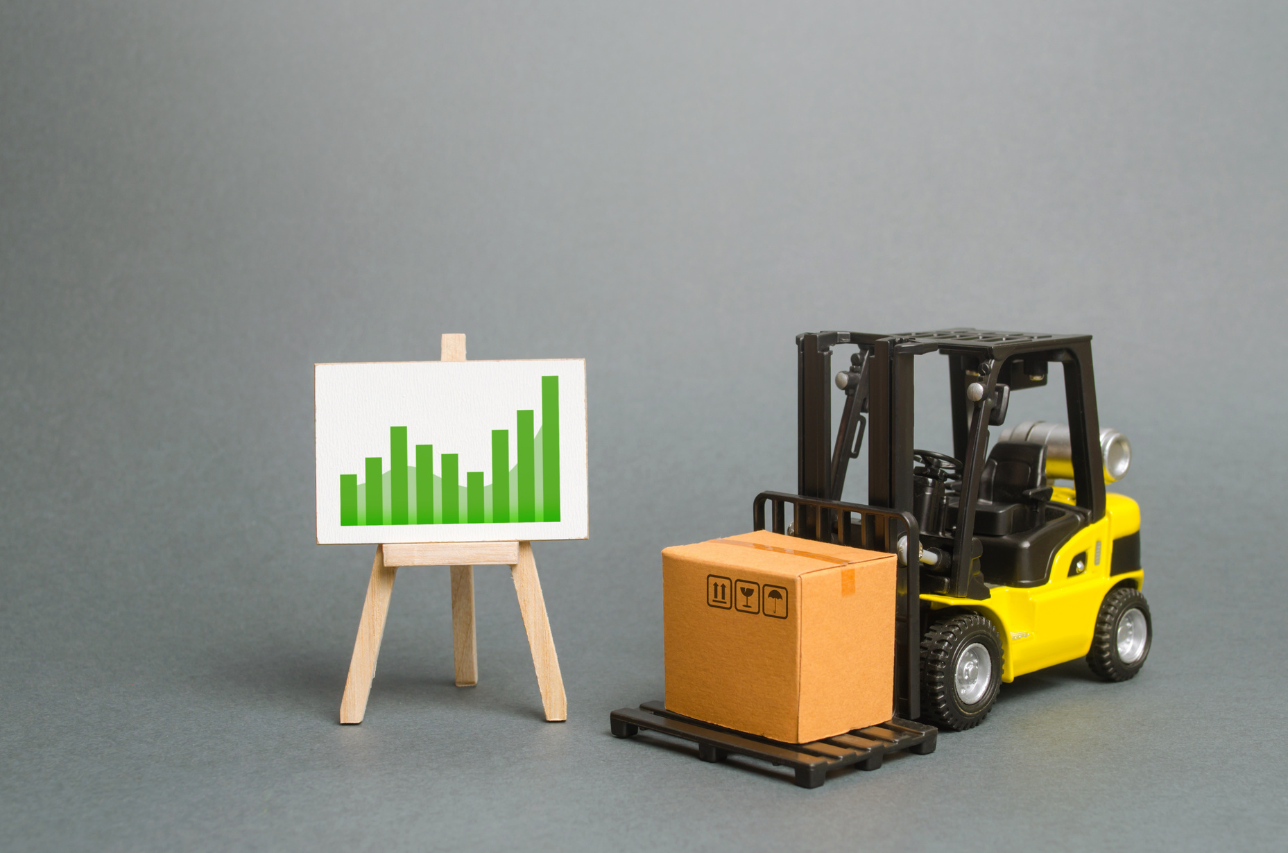 forklift truck carries a cardboard box and a sign with a positive trend. Profit growth from sales and high production of goods. Retail, resale, sales of products. Growth and stability of the economy.